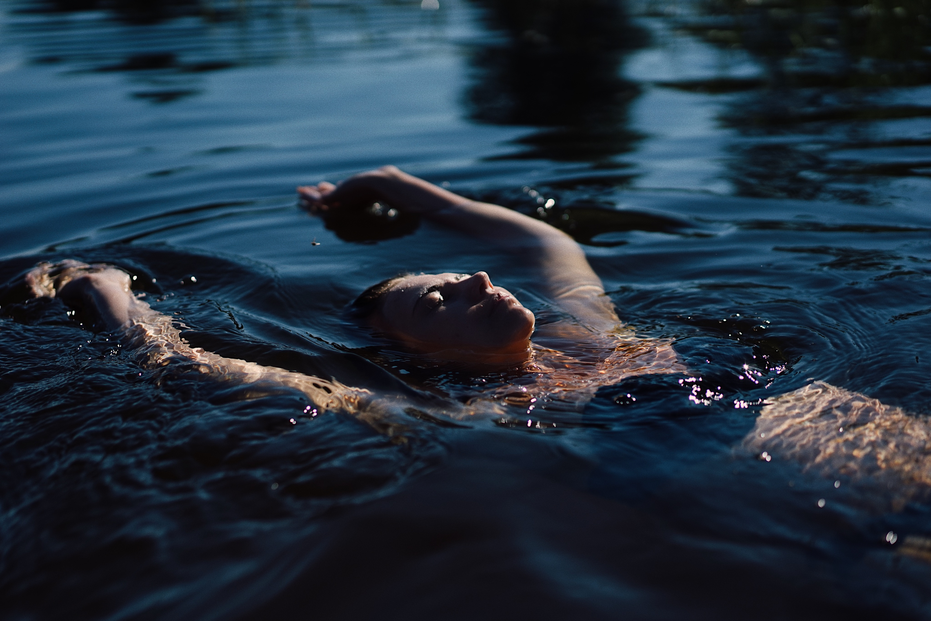 Woman relaxed wild swimming in natural surroundings