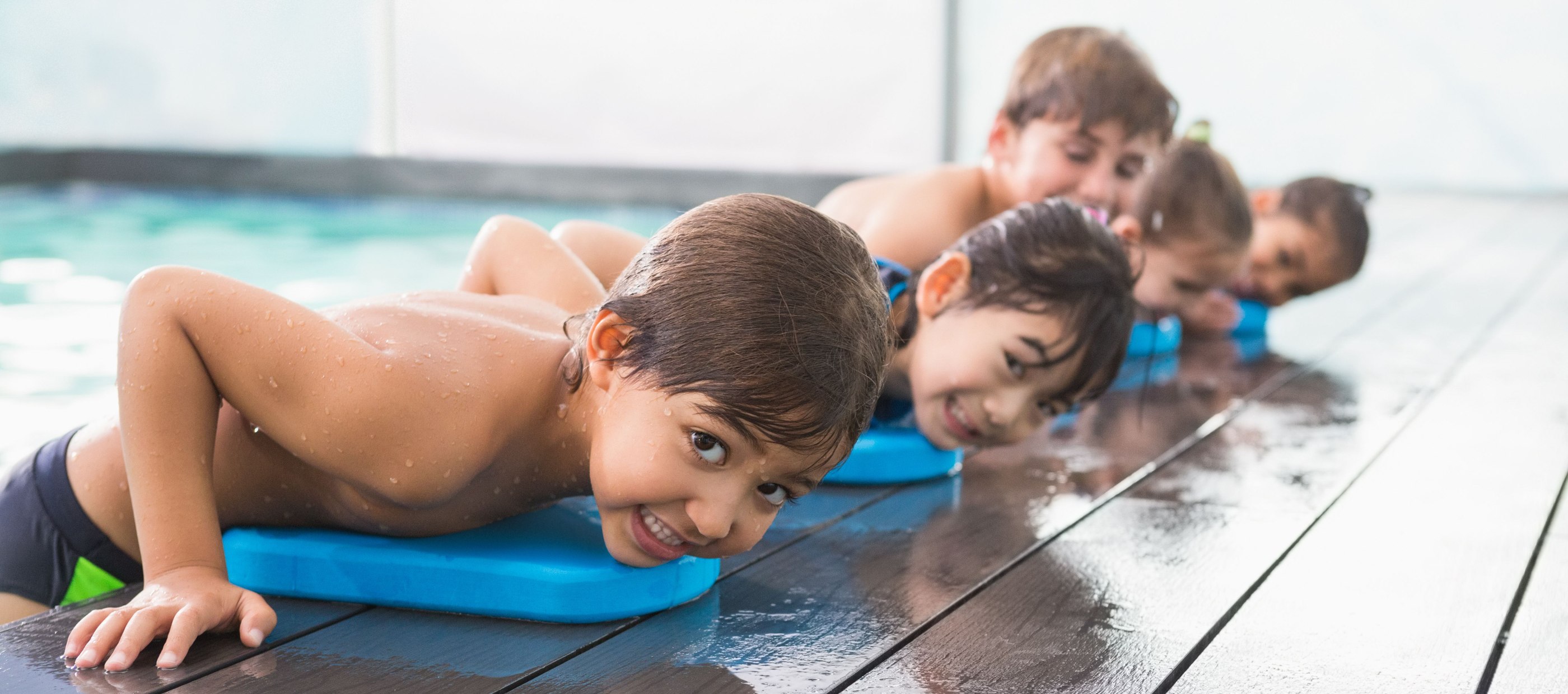 Child resting on side of pool
