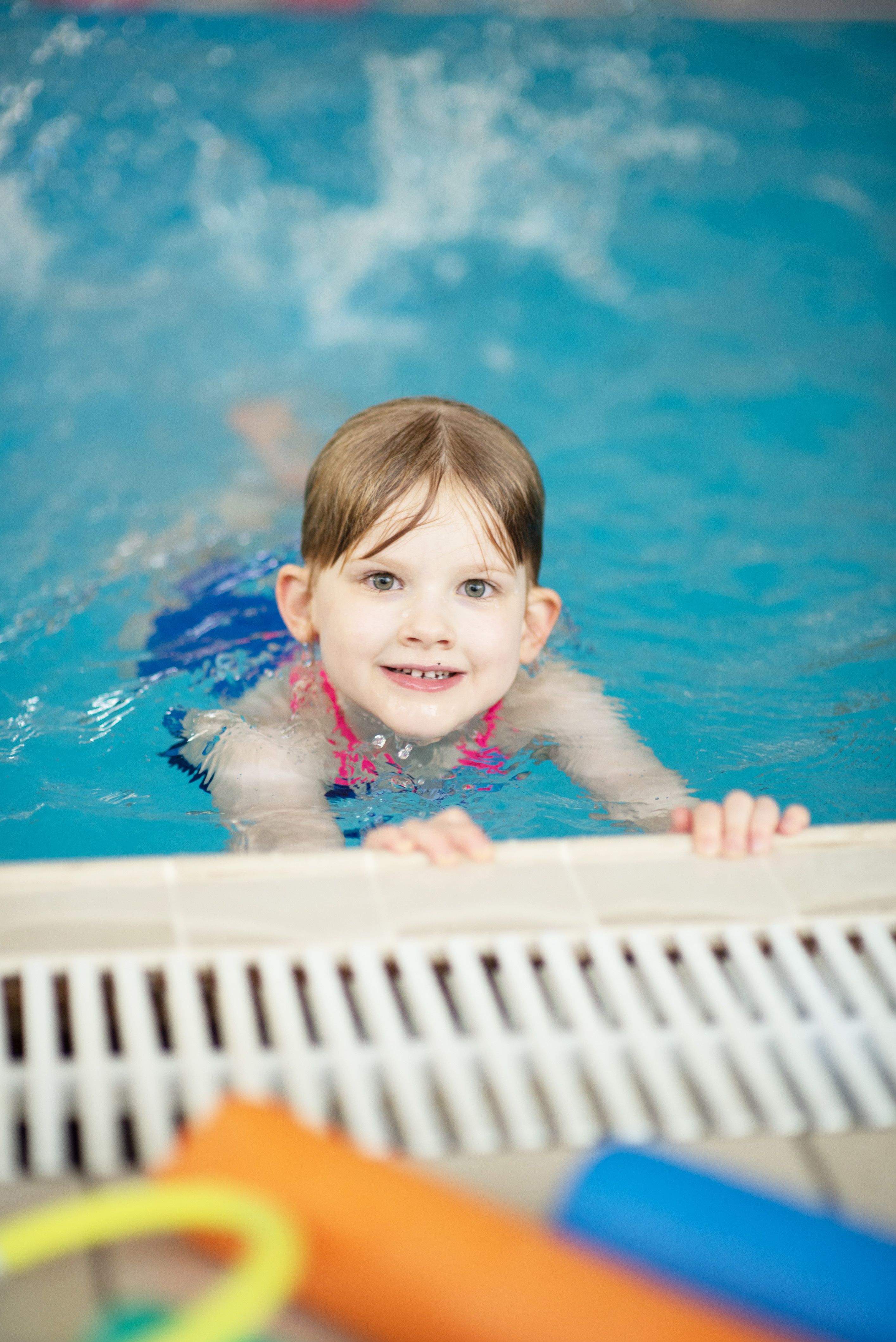 Child resting on side of pool