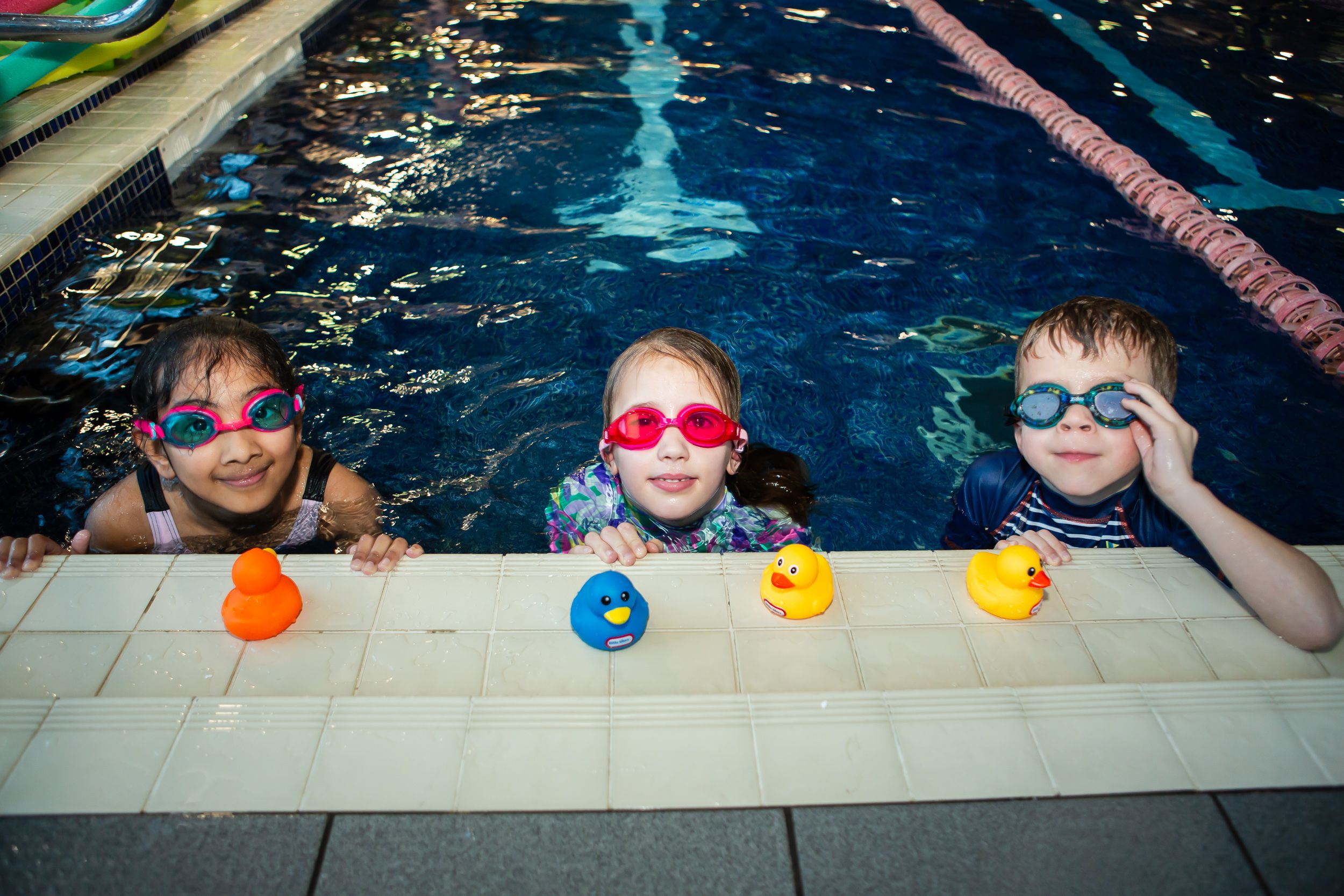 Children sitting on edge of pool